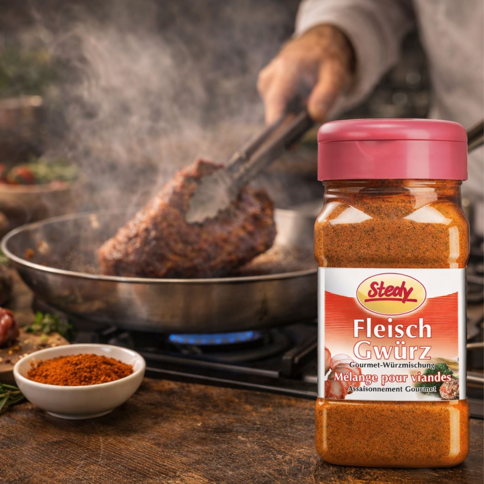 FleischGwürz von Stedy neben saftigem Steak auf Holzplatte, mit Rosmarin garniert.