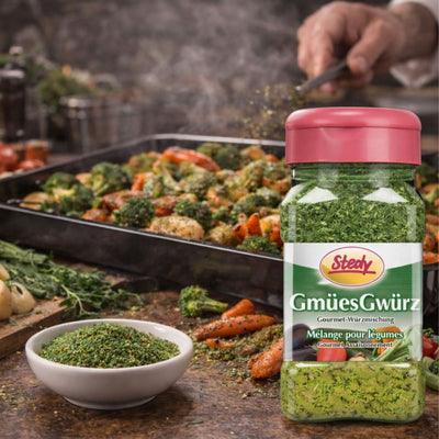 Gmües-Gewürz vor Grillplatte mit Gemüse und Streuer im Fokus.