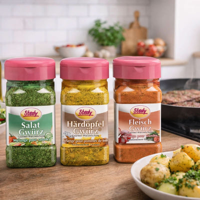 Drei Stedy Gewürze auf Küchentisch mit Kartoffelgericht im Hintergrund