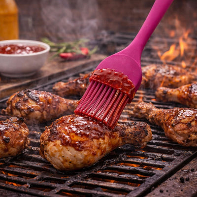 Grillpinsel im Einsatz beim Bestreichen von saftigem Grillfleisch mit Marinade