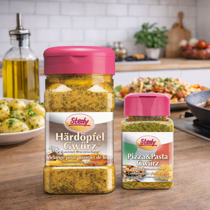 Stedy Härdöpfel Gewürz und Pizza & Pasta Gewürz auf Küchentisch mit Gericht im Hintergrund